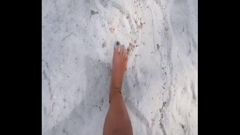 Belle fille sexy se promenant nue sur la plage